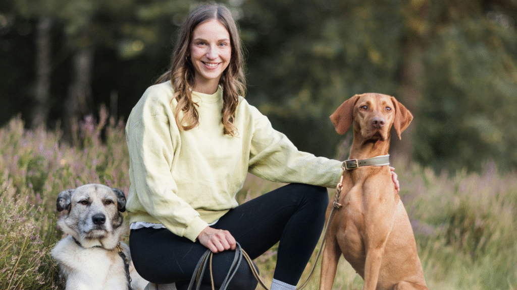 Hundetraining Münster - Rebecca von mindbodydog sitzt neben einem Jagdhund und einem Tierschutzhund in Münster im Wald