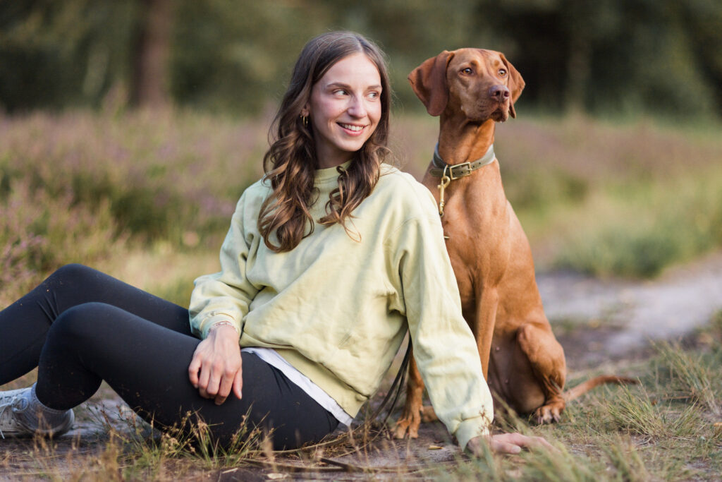 Entspannter Hund sitzt neben fröhlichem Mensch, symbolisiert Vertrauen im Hundetraining.